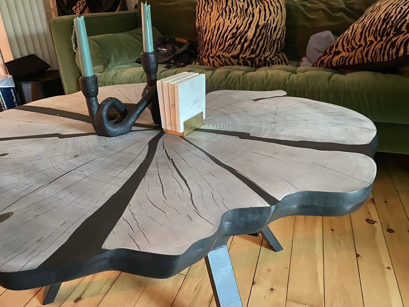Light live-edge coffee table with black filled cracks and a black edge, on steel legs